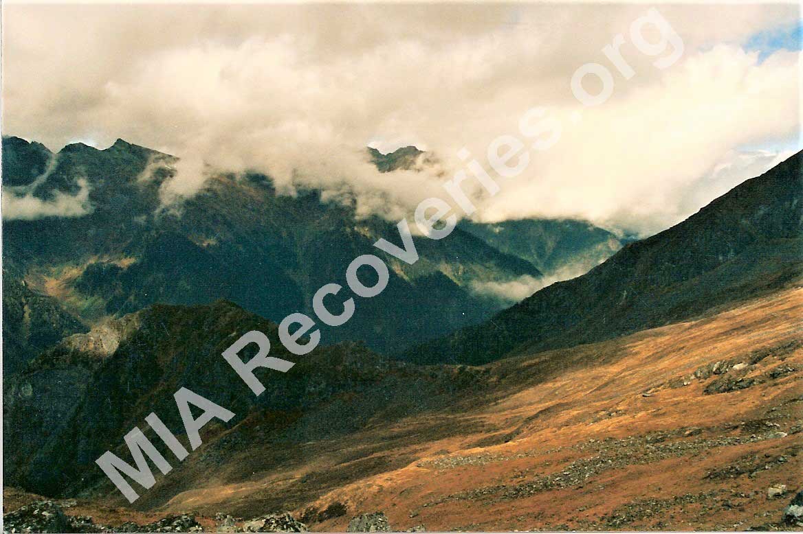 Crash site on grassy slope in background